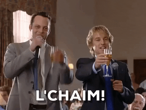 Movie gif. Vince Vaughn as Jeremy and Owen Wilson as John in wedding Crashers raise a toast. Text, “L'chaim!”