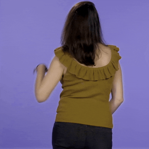 Video gif. Woman turns back to front, revealing a pregnant belly and smiling mysteriously, saying "Surprise!"