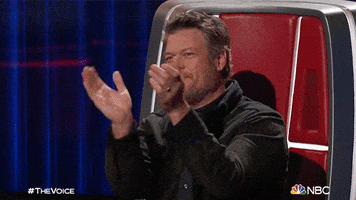 Reality TV gif. Blake Shelton on The Voice grins as he claps his hands energetically. 