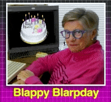 Video gif. Older woman sits at a desk in front of a computer with a birthday cake displayed on the screen. She nods slowly and awkwardly at us with a slight smile. Text, "Blappy Blarpday."