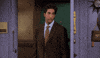 Friends gif. David Schwimmer as Ross stands near a door and looks annoyed as he gestures with his fists as if saying screw you. 