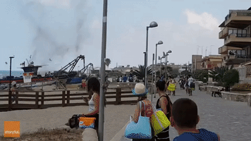 Beachgoers Run From Flying Debris Caused by Whirlwind