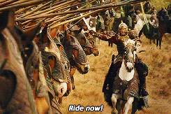 Movie gif. Eomer from The Lord of the Rings is dressed in heavy battle armor and rides a white horse. He holds his sword out as he rides along a row of knights on horseback, hitting his sword with their javelins. He lets out a battle cry and says, “Ride now!”