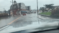 Cars Navigate Flooded Roads in Rhode Island Amid Weather Warnings