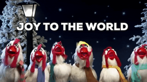 Muppets gif. Six chickens in scarves stand in a line and sing carols to us in front of an iron lamppost, two snowy pine trees, and a starry night backdrop. Text, “JOY TO THE WORLD.”