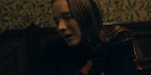 Movie gif. Morfydd Clark as Maud in Saint Maud tilts her head up and she collapses backwards slowly.