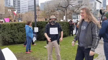 Man in Face Mask Offers Free Hugs During Anti-Lockdown Protest in Toronto