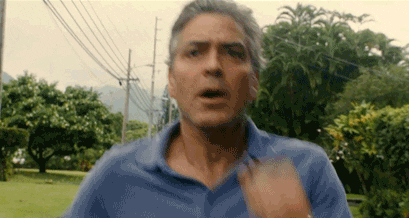 Movie gif. We get a frontal view of George Clooney as Matt King from The Descendants running worriedly through a narrow street, as he sprints past telephone lines and trees.