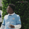 Sponsored gif. Man looks around with a confused look on his face before raising his arms in question.