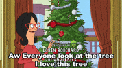 Cartoon gif. Linda Belcher on Bob’s Burgers stands next to a Christmas tree and happily looks around and up at the tree as she says, “Aw everyone look at the tree. I love this tree.”
