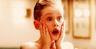 Movie gif. Macaulay Culkin as Kevin in Home Alone holds his hands to the side of his face with wide eyes as he yells. 