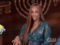 Celebrity gif. An excited and goofy Tyra Banks waves her hand, “hello.”