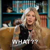 Sponsored gif. Traitors cast member Carolyn Wiger with a look of confused disbelief on her face says, “What?” Text also reads, “What?”