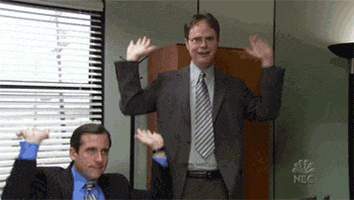 The Office gif. Steve Carrell as Michael Scott sits and Rainn Wilson as Dwight stands as they both bob and "raise the roof" with their arms.