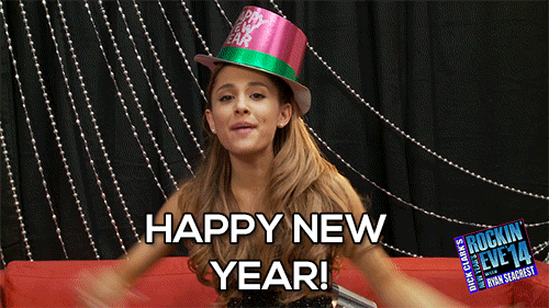 Celebrity gif. Ariana Grande sits on a couch at Dick Clarke’s New Year’s Rockin’ Eve 2014. She wears a pink Happy New Year top hat and throws her arms up in celebration as she says, "Happy New Year!”