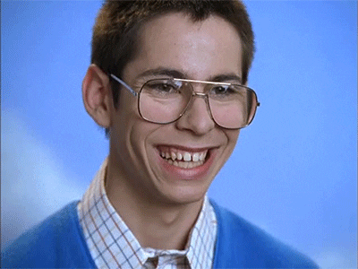 TV gif. Martin Starr as Bill Haverchuck in Freaks and Geeks flashes a wide smile for a yearbook photo, then drops it awkwardly.