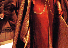 TV gif. Morena Baccarin as Inara from Firefly strides elegantly through a crowded room.