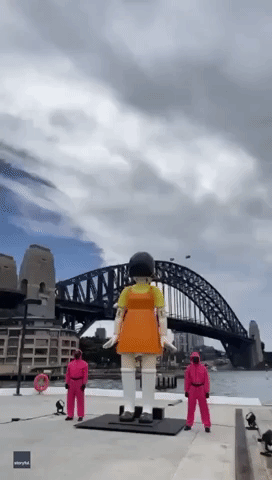 Creepy 'Squid Game' Doll Surveys Sydney Harbour