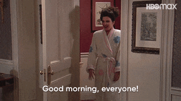 TV gif. Fran Drescher as Fran in The Nanny walks through a doorway in a bathrobe with her arms spread, jovial, greeting the family and saying "Good morning, everyone!" which appears as text.