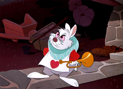 Disney gif. The White Rabbit from Alice in Wonderland is upset and impatient and has its hands on its hips. Their foot taps quickly on the floor and they hold a trumpet in one hand.