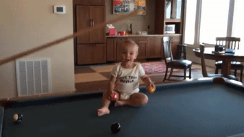 Baby has Laughing Fit Over Game of Pool