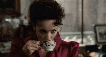 Movie gif. Rachel McAdams as Irene Adler from Sherlock Holmes stares intensely at Robert Downey Jr. playing Sherlock Holmes while sipping from her teacup. At first, Downey Jr. is confused but soon returns her strong gaze.