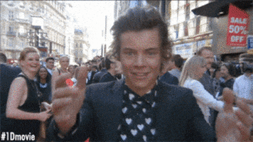 Celebrity gif. Harry Styles comes towards us with open arms and gives us a big smooch.