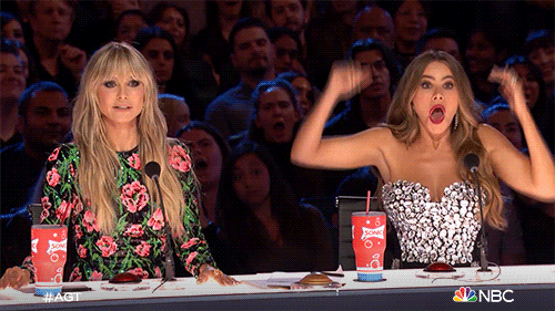 TV gif. Sofia Vergara throws her arms in the air and drops her jaw next to a stunned Heidi Klum on America's Got Talent. 