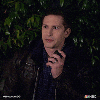 TV gif. Andy Samberg as Detective Jake Peralta from Brooklyn Nine-Nine judgmentally grimaces while clutching onto a walkie-talkie.