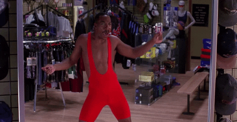 Movie gif. Eddie Murphy as Buddy Love in The Nutty Professor is in a clothing store, in front of a mirror. He wears a red spandex wrestling singlet and gyrates his hips side to side, raising his arm up hyping himself up, looking in the mirror excitedly.