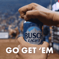 Sponsored gif. Hand opens a can of Busch Light and it foams from the top. In the background, a cowboys rides a bucking bull at a rodeo. Text reads, “Go get ‘em.”