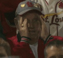 Video gif. St. Louis Cardinals fan sits in the audience with his hands on his face like horse blinders. He has a worried look in his eyes and then he covers his eyes because he’s too scared to look.