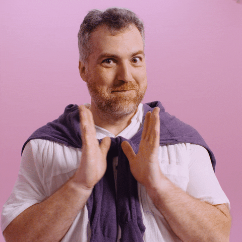 Video gif. A bearded man in preppy attire happily dances and claps in celebration.