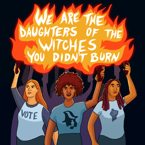 Illustrated gif. Three women leading a crowd, wearing t-shirts bearing a raised fist, the women's march logo, and "vote," holding torches high above their heads, forming one giant flame with the message, "We are the daughters of the witches you didn't burn."