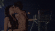 Movie gif. Karla Souza and Ricardo Abarca as Maru and Renato in Que Culpa Tiene el Niño, sharing a passionate kiss before the screen fades into and explosion of tie dye.