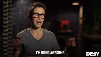 Reality TV gif. A Forged in Fire contestant wearing a gray t-shirt and glasses smiles as she tells us: Text, "I'm doing awesome."