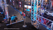 Reality TV gif. A boy on American Ninja Warrior steps onto a stage pumped up as smoke shoots up around him. Text, "Let's go." 