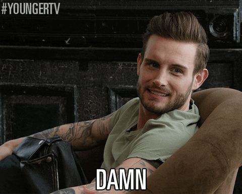 TV gif. Nico Tortorella as Josh on Younger looks over his shoulder and furrows his eyebrows, shocked. He says, “damn,” and then turns his head back around. 