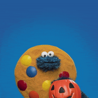 gif of Cookie Monster on a blue background, wearing a cookie costume and holding a pumpkin shaped bucket. Text reads, "Trick or Treat!"