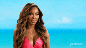 Reality TV gif. Candiace Dillard Bassett is on The Real Housewives Ultimate Girls Trip. She's being interviewed in front of a gorgeous beach and she rolls her eyes so heavily, her neck turns with it.