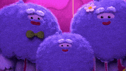 Cartoon gif. Three yetis from True and the Rainbow Kingdom simultaneously applauding and smiling.