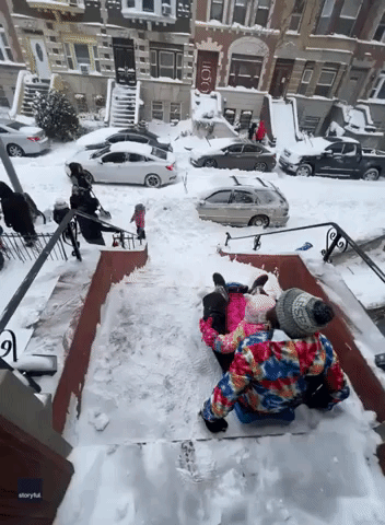 New Yorkers Sled Down Snow-Covered Steps During Winter Storm