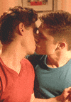 Video gif. Two men are in the middle of a lovely kiss and they both begin to smile as the kiss lingers on.