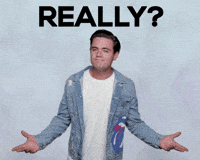 Celebrity gif. Luke Cosgrove leans forward, staring at us as he shrugs his arms. He has a smirk on his face and nods as he says, “Really?”