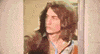 Video gif. Man wearing a butterfly collar shirt opens a door, then quakes with shock as his eyes bug out and his mouth gapes open.