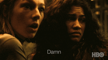 TV gif. Hunter Schafer as Jules in Euphoria looks in shock as she turns to Zendaya as Rue who frowns and says, "Damn."