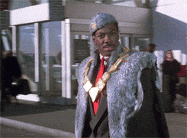 Movie gif. Eddie Murphy as Prince Akeem in Coming to America steps onto a road at an airport and confidently holds his hand out, a taxi braking to try and stop without hitting him.