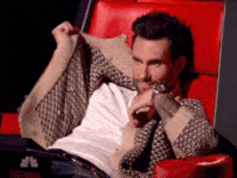 Reality TV gif.  Adam Levine sits in his coach's chair for The Voice and he slumps down, covering his face with his cardigan. 