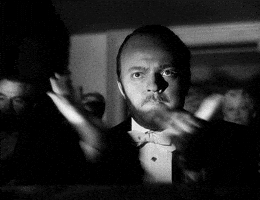 Movie gif. Orson Welles as Kane in Citizen Kane, looks extremely serious and claps vehemently.