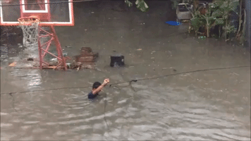 Locals Swim Through Flooded Streets After Tropical Depression Maring Hits Quezon City